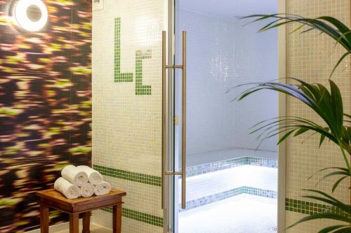 屈伊朗Hotel La Chaumière的浴室内配有带毛巾的淋浴