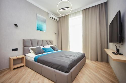 敖德萨Ванный переулок Апартаменты Миконос的一间卧室配有一张大床和电视