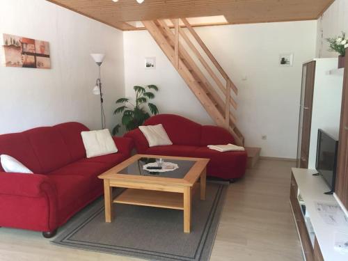 弗雷门Ferienwohnung bi Klatt tu Hus的客厅配有红色沙发和茶几