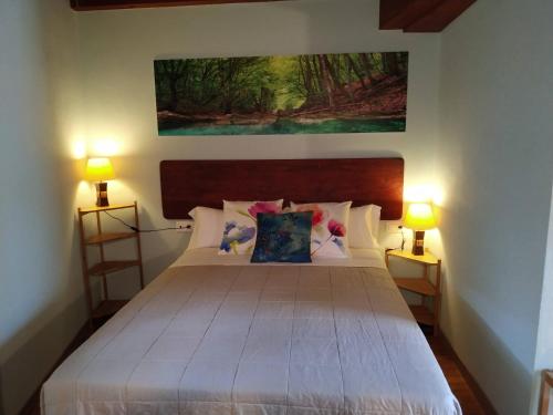 阿里翁达斯El interior de Gaia的一间卧室配有一张带两盏灯的大型白色床。