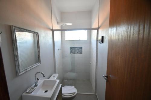 拉古纳Pousada Barra Sul的浴室配有卫生间、盥洗盆和淋浴。