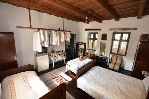 MădăraşCasa Traditionala Ardeleana的一间卧室设有两张床、一张桌子和窗户。