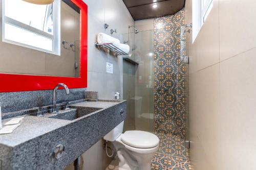 里约热内卢蒙特卡斯特罗酒店的一间带卫生间、水槽和镜子的浴室