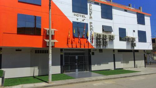 塔拉拉HOTEL PUNTA PARIÑAS-TALARA-PERU的街道边的橙色和白色建筑