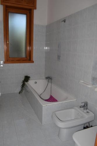 玛丽娜迪曼卡维萨Alba Chiara - Villa con Giardino的带浴缸、卫生间和盥洗盆的浴室