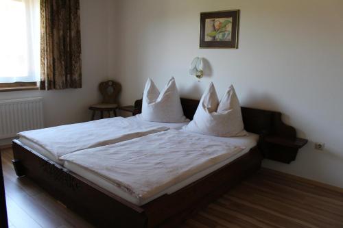 Lungötz卡夫公寓的一间卧室配有带白色床单和枕头的床。
