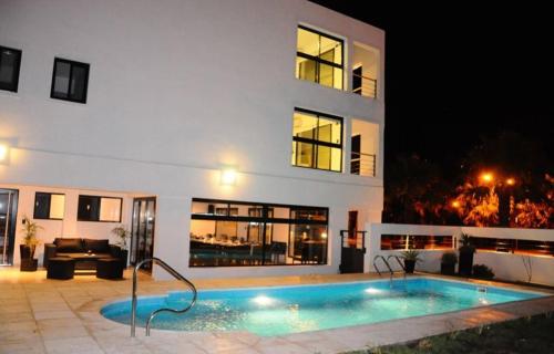 米拉马尔Andaluhe Posada的一座游泳池,在晚上在建筑物前