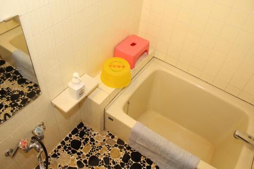 汤泽町高半旅馆的带浴缸和粉红色盒子的浴室