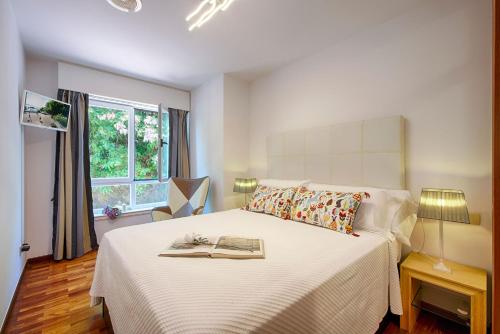 奥莱罗斯apartamento santa cruz oleiros的一间卧室配有一张床,上面有一本书