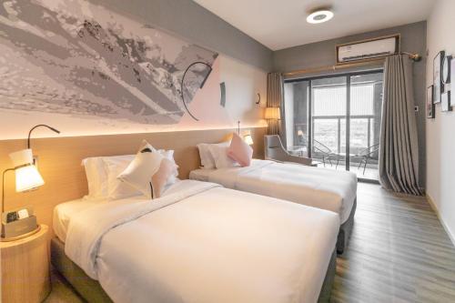 花都广州安谧度假酒店的酒店客房设有两张床和窗户。