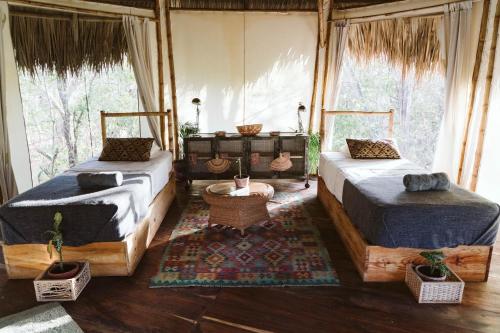 南圣胡安Dreamsea Surf Resort Nicaragua的带窗户的客房内的两张床