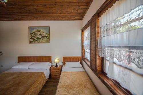 培拉特卡拉亚酒店的一间卧室设有两张床和窗户。
