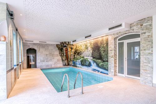 科莱伊萨尔科阿尔平戈珍酒店的瀑布壁画房子内的游泳池