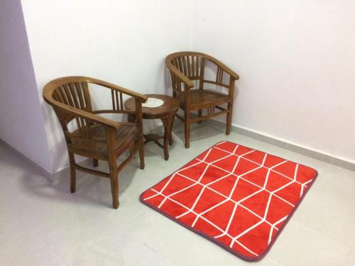 丹那美拉Sesuci Murni Homestay的房间里的两张椅子和红色地毯