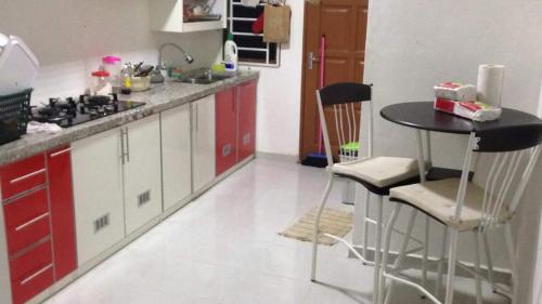 丹那美拉Sesuci Murni Homestay的厨房配有红色橱柜和桌椅
