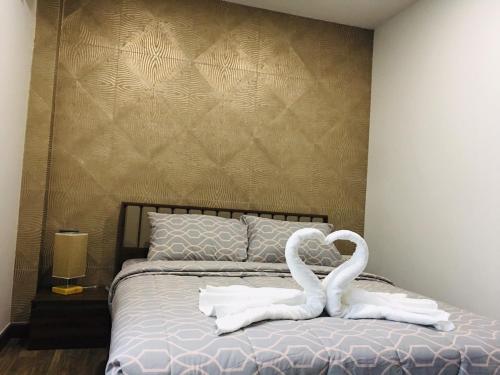 清迈SB Holiday Resort的两只白天鹅坐在床上