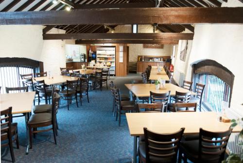 米尔顿凯恩斯National Badminton Centre Lodge & Health Club的用餐室配有桌椅
