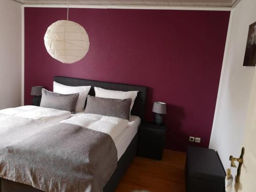 门登Ferienwohnung Menden的一间卧室配有一张大床和紫色墙壁