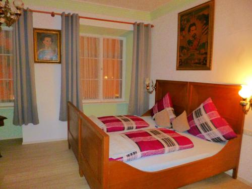 福森Lucky Home Ludwig Appartment的一间卧室配有一张带红色和白色枕头的木床。