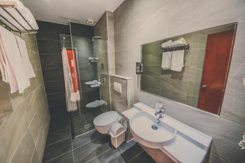 萨兰达考尼亚酒店的一间带水槽、卫生间和淋浴的浴室