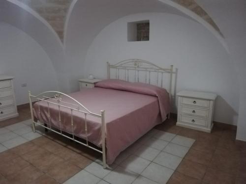 曼杜里亚Casa Daniela的一间卧室配有一张带粉红色床罩的床