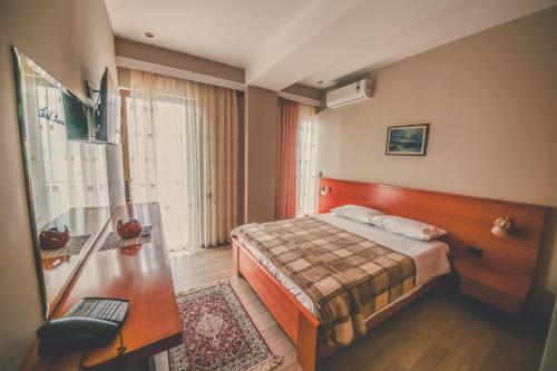 萨兰达考尼亚酒店的配有一张床和一张书桌的酒店客房