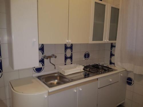 莱波拉诺Villa Giada-8 appartamenti的厨房配有水槽和炉灶