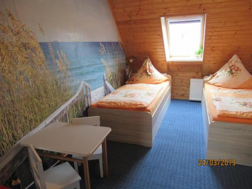 Dändorf3***Ferienwohnungen Neumann的客房设有两张床、一张桌子和一扇窗户。