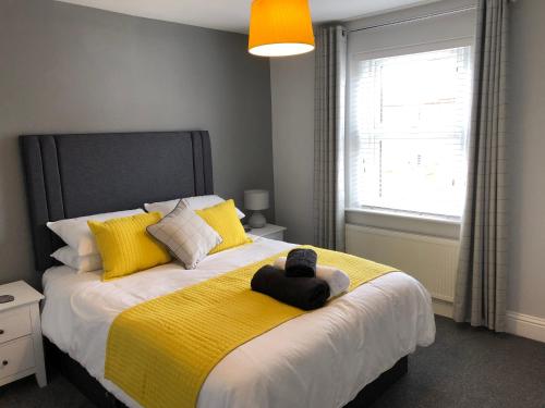 林肯Archie's Cottage的一间卧室配有一张带黄色毯子的大床