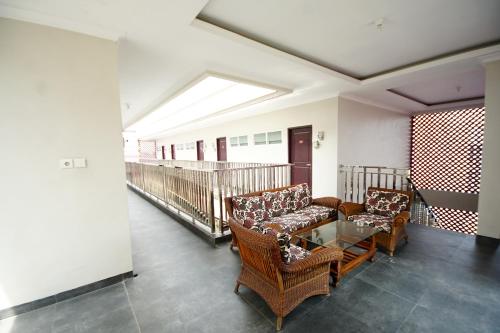 Talang KelapaSuper OYO 270 Madinah Residence Syariah的客厅配有两把椅子和一张玻璃桌