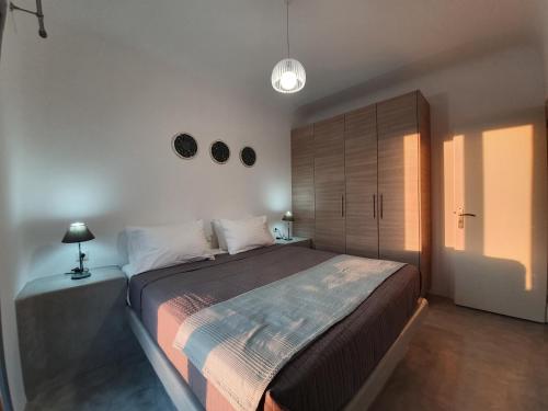 安坡里奥圣托里尼Villa Therme Athena的一间卧室配有一张大床和木柜