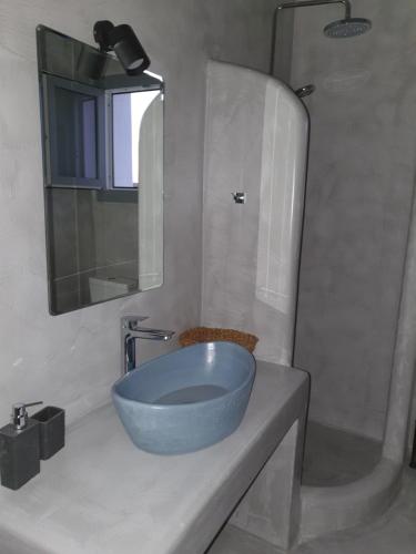 安坡里奥圣托里尼Villa Therme Athena的浴室设有蓝色水槽和镜子