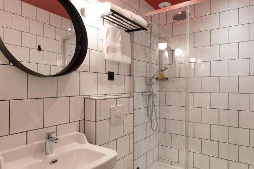 兰斯Hôtel Bristol Reims的白色瓷砖浴室设有水槽和镜子