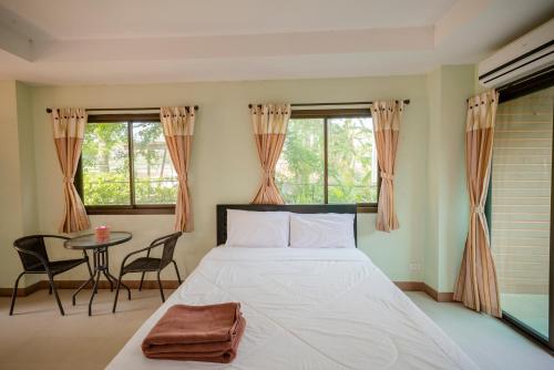 南邦Banlanna Hotel Lampang的卧室配有床、桌子和窗户。