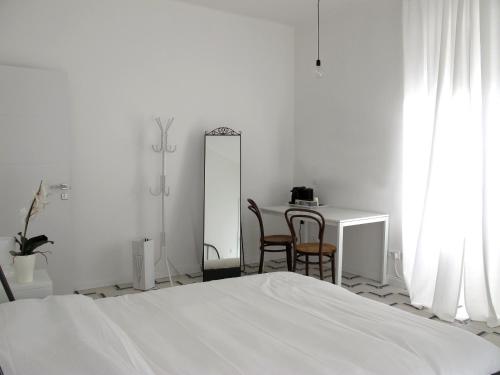 莱里奇Il Capitano的白色卧室配有床和桌椅