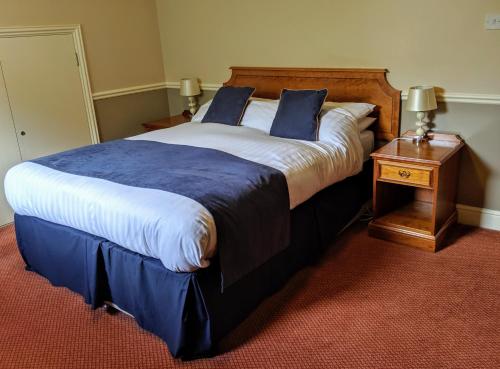 滕特登London Beach Country Hotel & Golf Club的一间卧室配有一张带蓝白色床单的大床