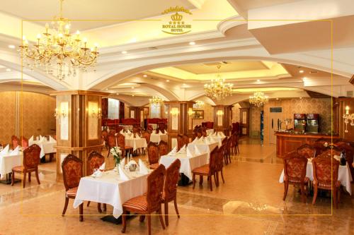 乌兰巴托皇家2号酒店的餐厅设有白色的桌椅和吊灯。