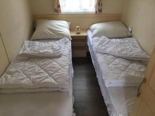 韦默尔丁厄Caravanverhuur Zeeland的小型客房 - 带2张床和窗户