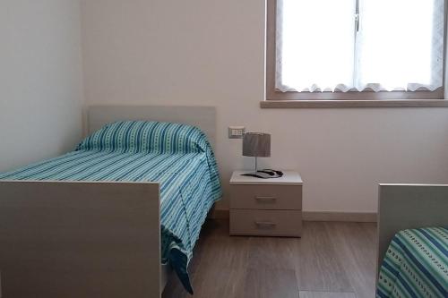 莫尔韦诺Chalet La Perla Molveno的一间卧室设有两张床、床头柜和窗户。