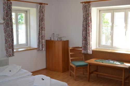 哈尔施塔特Gingin- rooms的客房设有一张床、一张书桌和窗户。