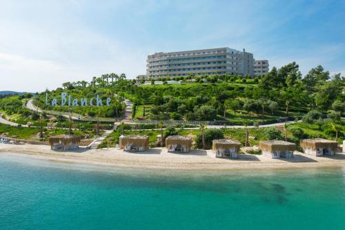 GuvercinlikLa Blanche Island Bodrum的海洋中的岛屿,有建筑背景