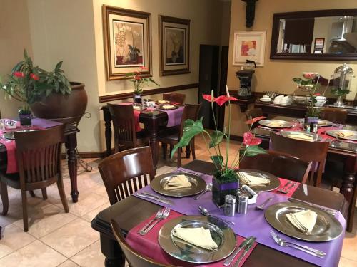 约翰内斯堡适子莫酒店的一间设有桌椅和紫色桌子的用餐室