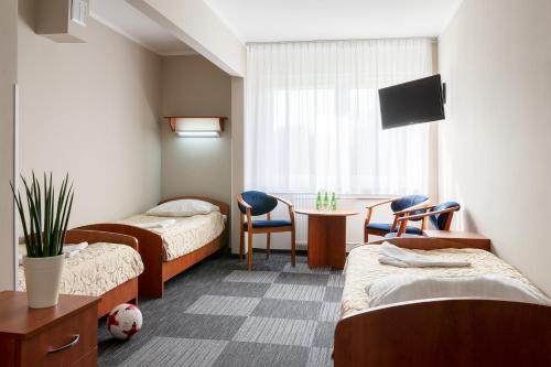 比得哥什兹瓦斯艾酒店的一间医院间,配有两张床和一张桌子及椅子