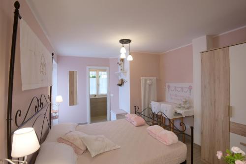 泰塞罗B&B Magiré的一间卧室配有带粉红色枕头的床。