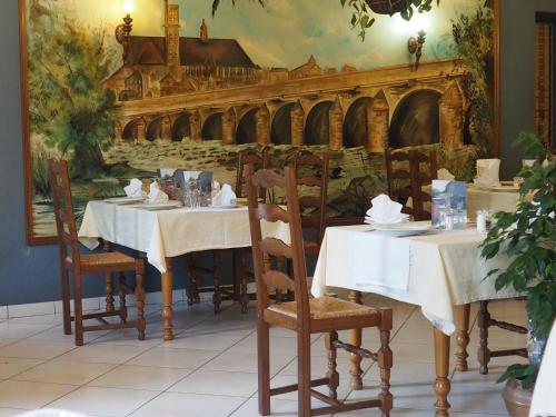 Dornecy拉曼瑟酒店及餐厅的一间设有两张桌子的餐厅,还有一幅桥画