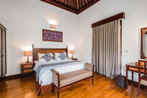 克罗柏坎Aldeoz Grand Kancana Villas Resort Bali的一间卧室设有床、两张桌子和一扇窗户