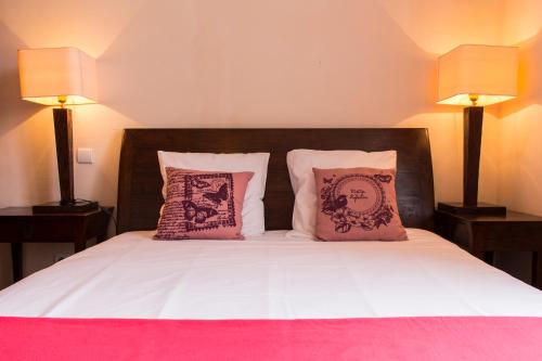 巴巴斯特莱斯巴斯提阿布莱特高尔夫酒店的一张带粉色和白色床单的床和两盏灯