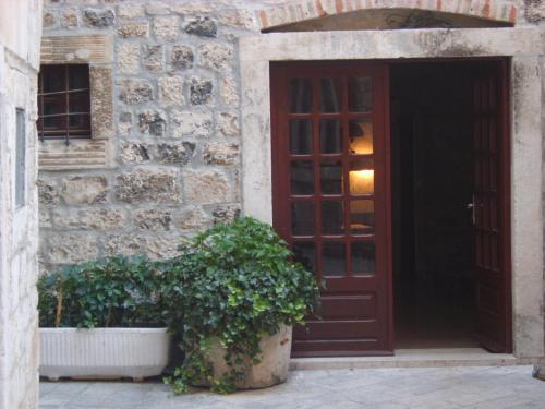 特罗吉尔洛索旅舍的前方有两株盆栽植物的建筑物的门