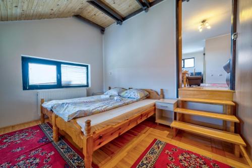 兹拉蒂博尔Kuća za odmor Žunić的一间卧室设有木床和楼梯。