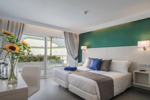 甘迪亚海滩埃斯金索滨海山庄公寓式酒店的一间卧室配有一张大床和花瓶